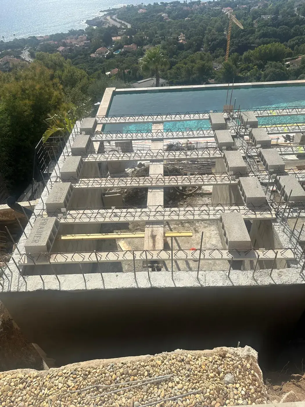 Vue plongeante sur la structure ferraillée d'une piscine en construction